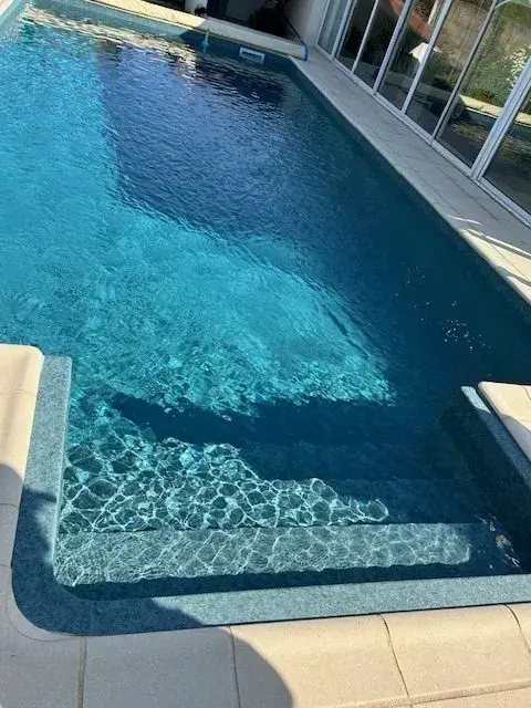 Maison contemporaine : Piscine granit vert avec intégration paysagère